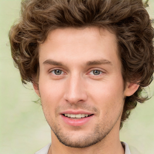 Joyful white young-adult male with short  brown hair and green eyes