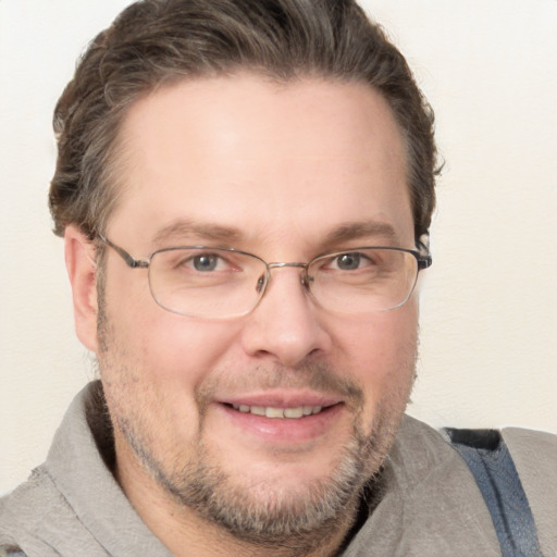 Joyful white adult male with short  brown hair and blue eyes