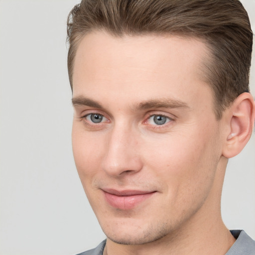 Joyful white young-adult male with short  brown hair and grey eyes