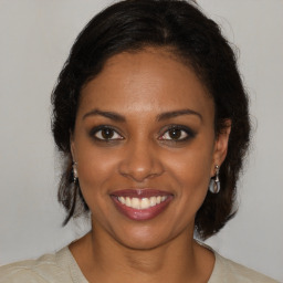 Joyful black young-adult female with medium  brown hair and brown eyes