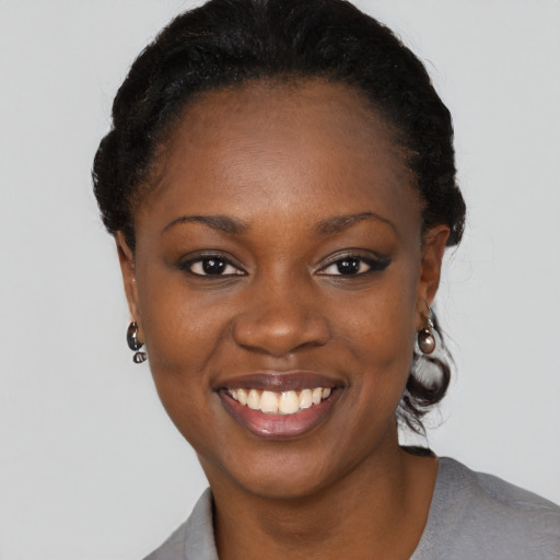 Joyful black young-adult female with short  black hair and brown eyes