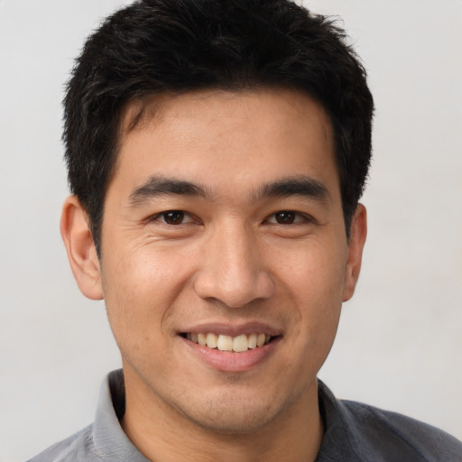 Joyful white young-adult male with short  black hair and brown eyes