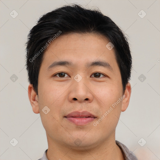 Joyful asian young-adult male with short  brown hair and brown eyes