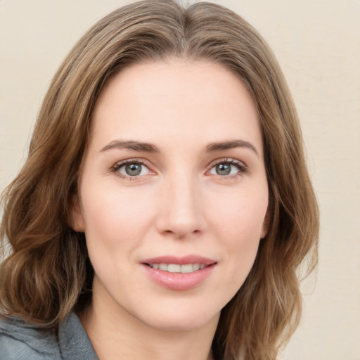 Joyful white young-adult female with medium  brown hair and green eyes