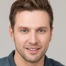 Joyful white young-adult male with short  brown hair and grey eyes