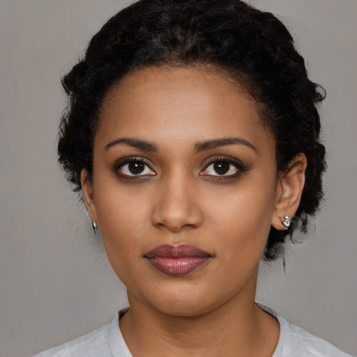 Joyful black young-adult female with medium  black hair and brown eyes
