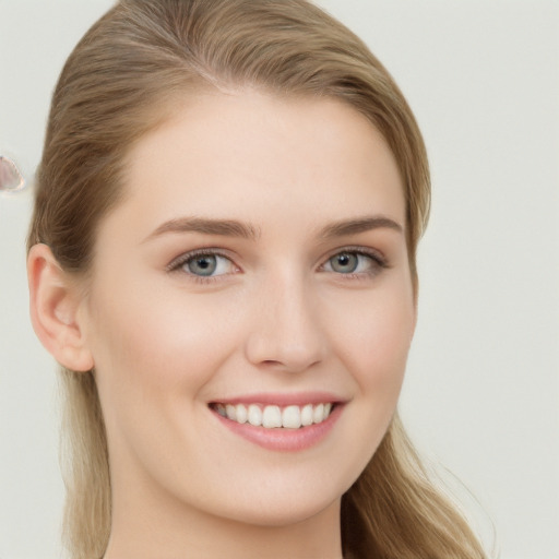 Joyful white young-adult female with long  brown hair and grey eyes