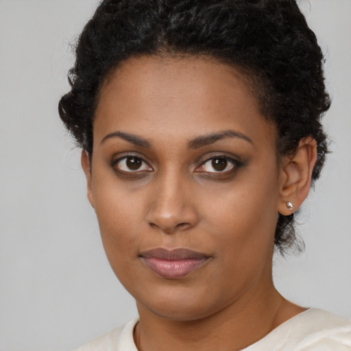 Joyful black young-adult female with short  brown hair and brown eyes