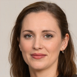 Joyful white adult female with long  brown hair and grey eyes