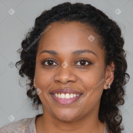 Joyful black young-adult female with long  brown hair and brown eyes