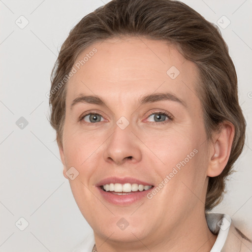 Joyful white adult female with medium  brown hair and grey eyes