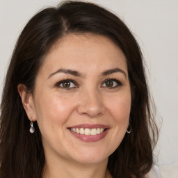 Joyful white adult female with long  brown hair and brown eyes