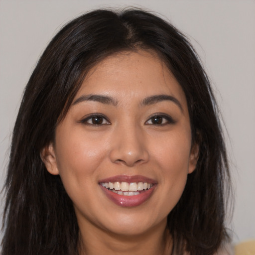 Joyful latino young-adult female with long  brown hair and brown eyes