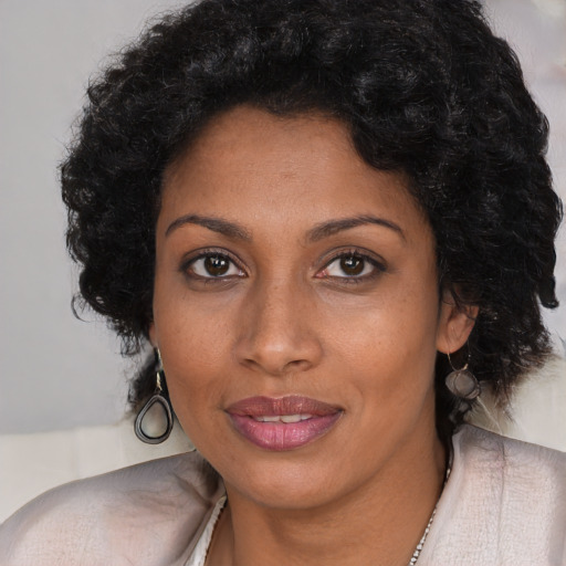 Joyful black young-adult female with long  black hair and brown eyes