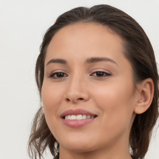 Joyful white young-adult female with long  brown hair and brown eyes