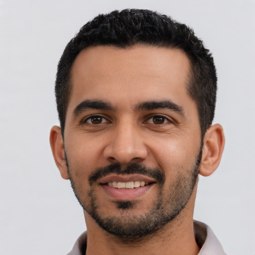 Joyful latino young-adult male with short  black hair and brown eyes