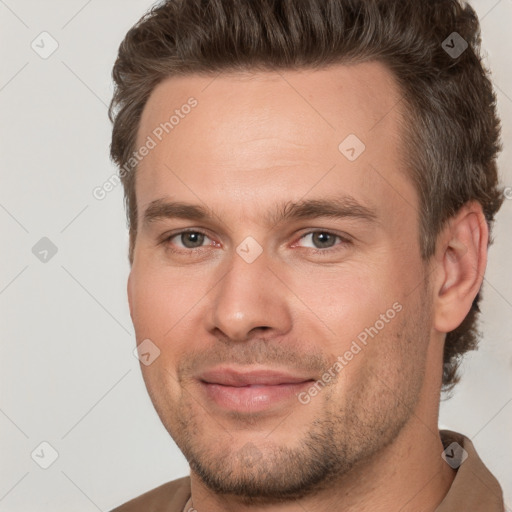 Joyful white adult male with short  brown hair and brown eyes