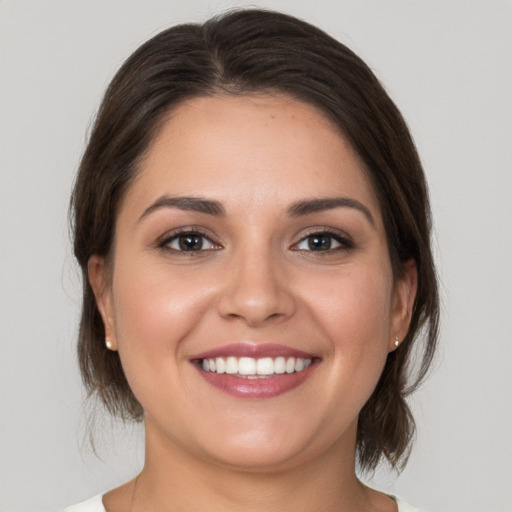 Joyful white young-adult female with medium  brown hair and brown eyes