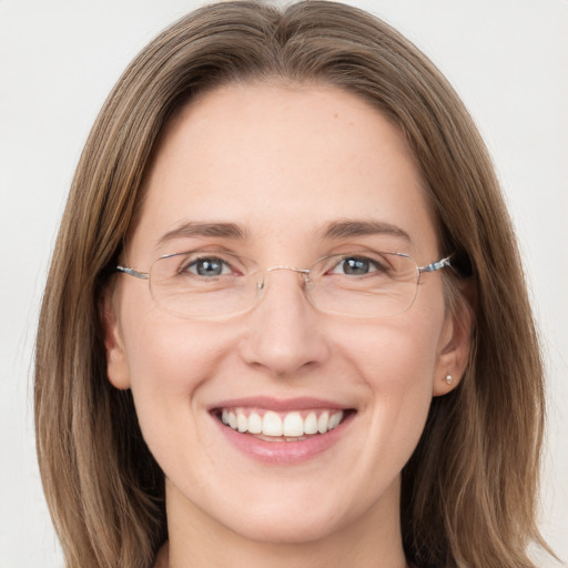 Joyful white young-adult female with long  brown hair and grey eyes