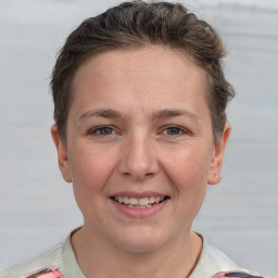 Joyful white young-adult female with short  brown hair and grey eyes