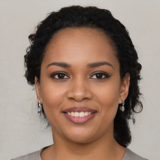 Joyful black young-adult female with medium  black hair and brown eyes