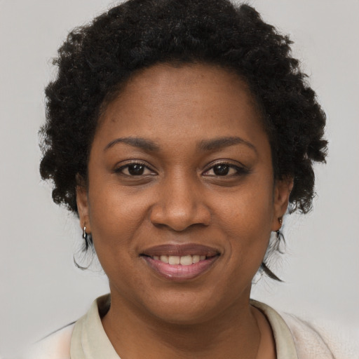 Joyful black young-adult female with short  brown hair and brown eyes