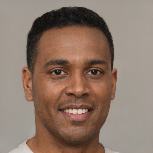 Joyful latino young-adult male with short  brown hair and brown eyes