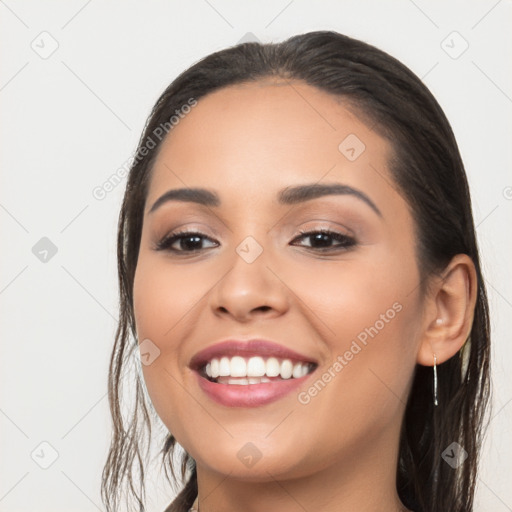 Joyful latino young-adult female with long  brown hair and brown eyes