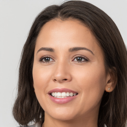 Joyful white young-adult female with long  brown hair and brown eyes