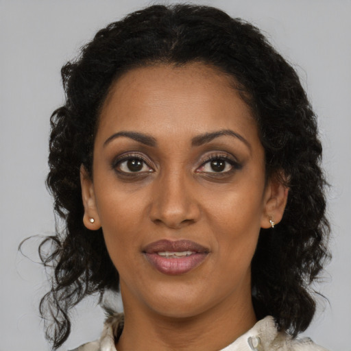 Joyful black adult female with medium  brown hair and brown eyes