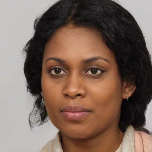 Joyful black young-adult female with long  black hair and brown eyes