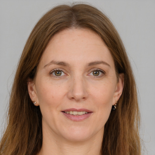 Joyful white adult female with long  brown hair and green eyes