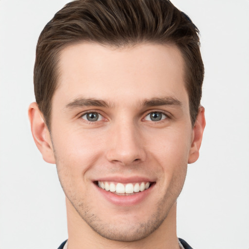 Joyful white young-adult male with short  brown hair and grey eyes