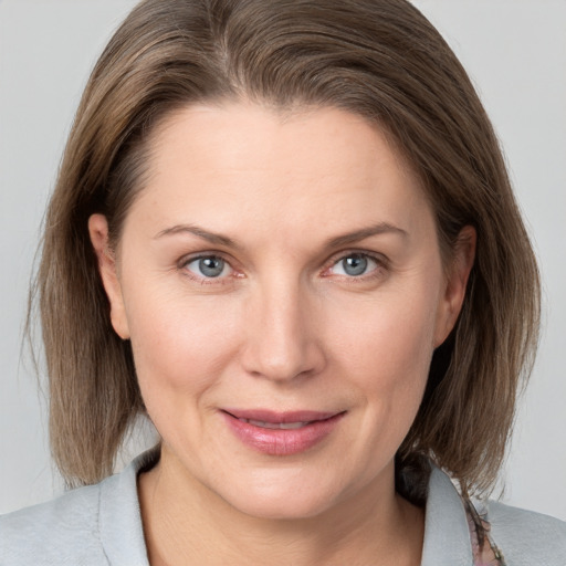 Joyful white adult female with medium  brown hair and grey eyes