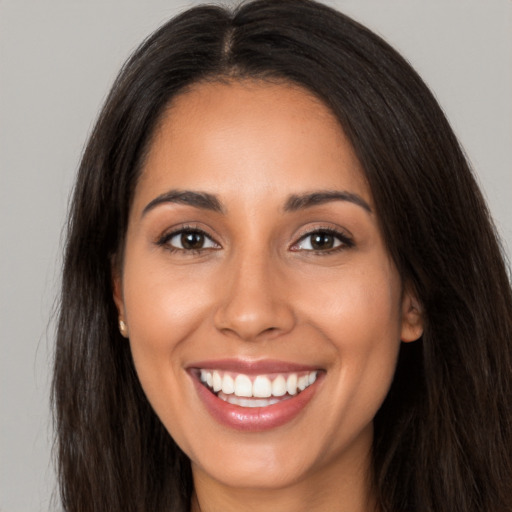 Joyful latino young-adult female with long  brown hair and brown eyes