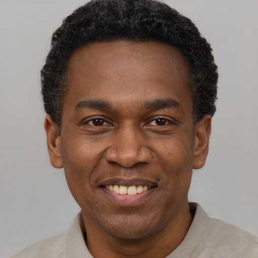 Joyful black adult male with short  black hair and brown eyes