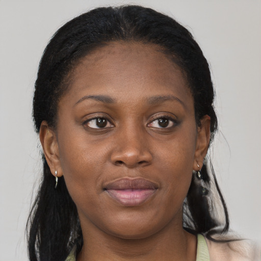 Joyful black young-adult female with long  brown hair and brown eyes