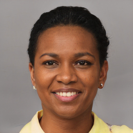 Joyful black young-adult female with short  black hair and brown eyes