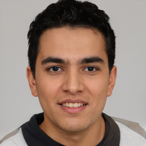 Joyful latino young-adult male with short  brown hair and brown eyes