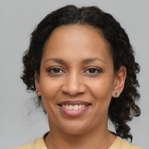 Joyful latino adult female with medium  brown hair and brown eyes