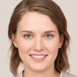 Joyful white young-adult female with medium  brown hair and blue eyes