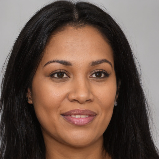 Joyful latino young-adult female with long  brown hair and brown eyes