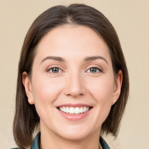 Joyful white young-adult female with medium  brown hair and grey eyes