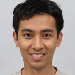 Joyful asian young-adult male with short  black hair and brown eyes