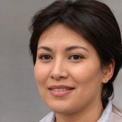 Joyful asian adult female with medium  brown hair and brown eyes