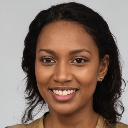 Joyful black young-adult female with long  brown hair and brown eyes