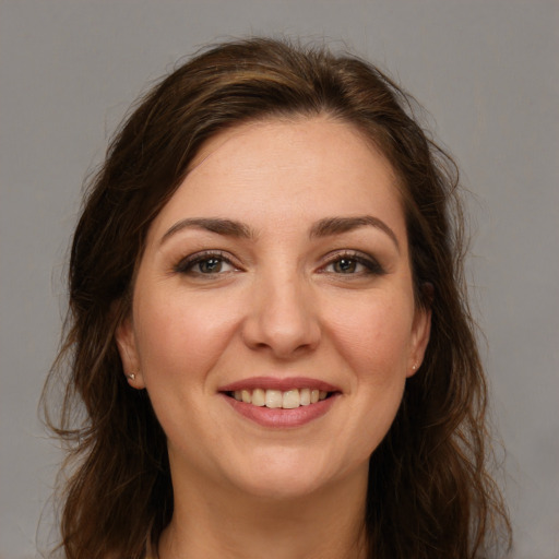 Joyful white young-adult female with long  brown hair and grey eyes