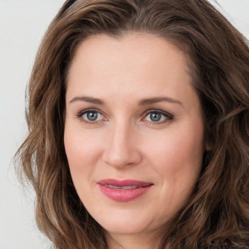 Joyful white young-adult female with long  brown hair and green eyes