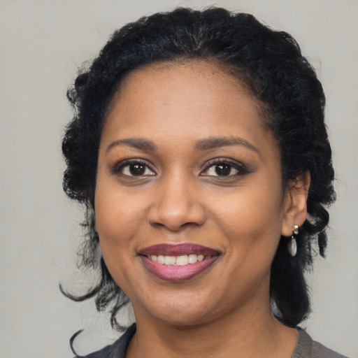 Joyful black young-adult female with medium  brown hair and brown eyes