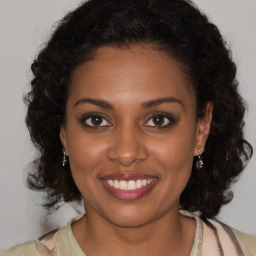 Joyful black young-adult female with medium  brown hair and brown eyes